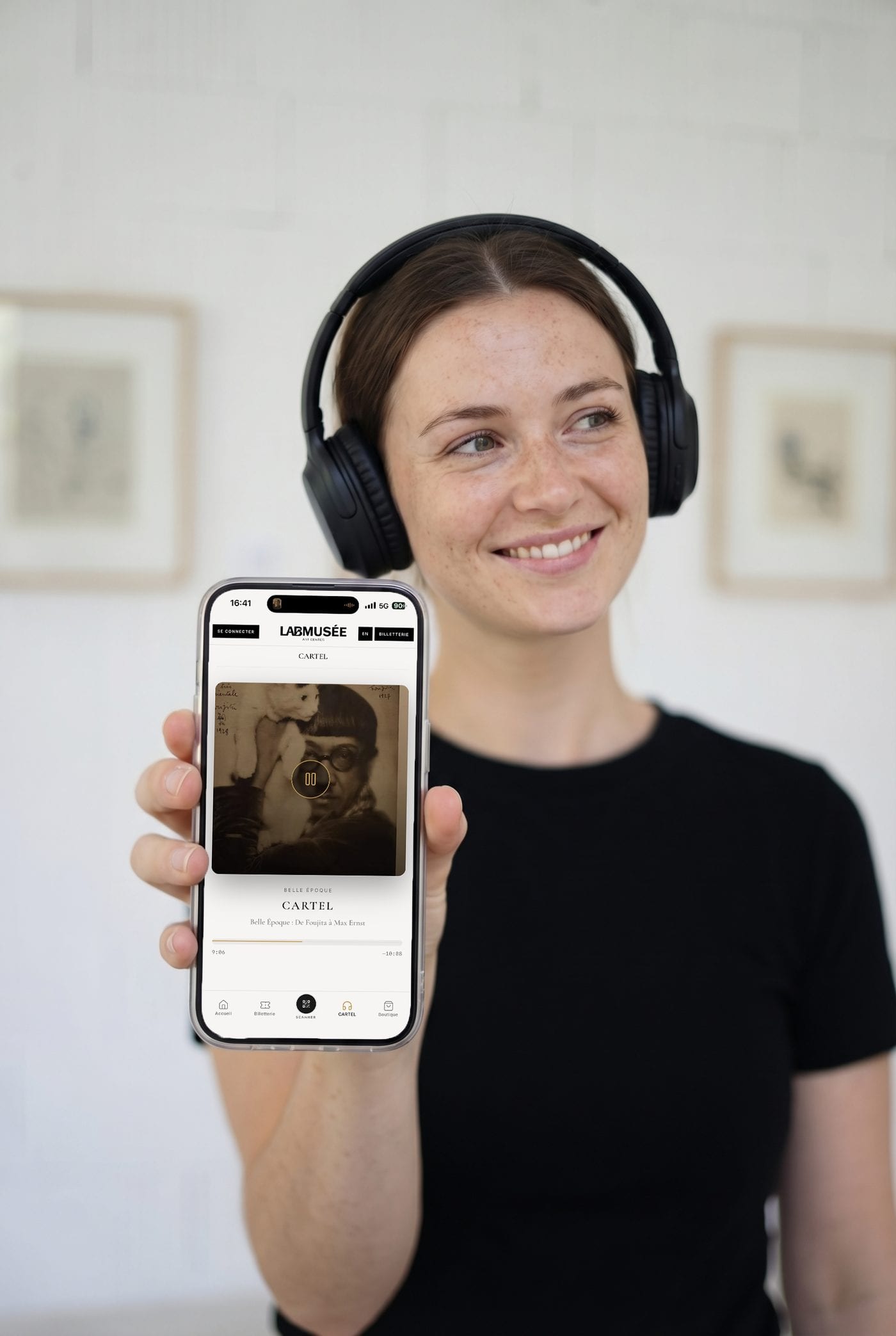 Une visiteuse écoute au casque le podcast d'une exposition sur l'application LabMusée