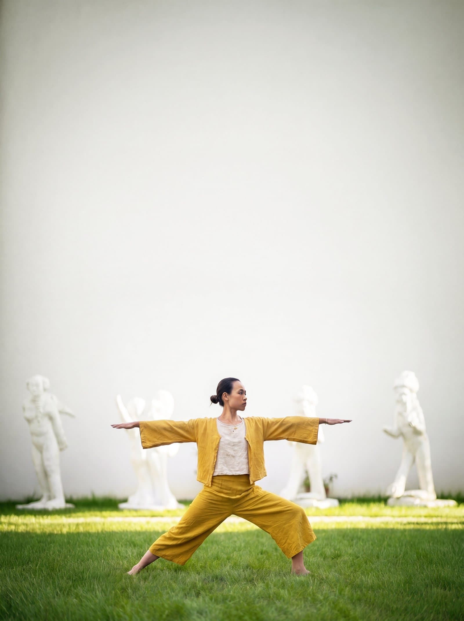 Sarah Fu en posture du guerrier dans le jardin de sculptures du LabMusée